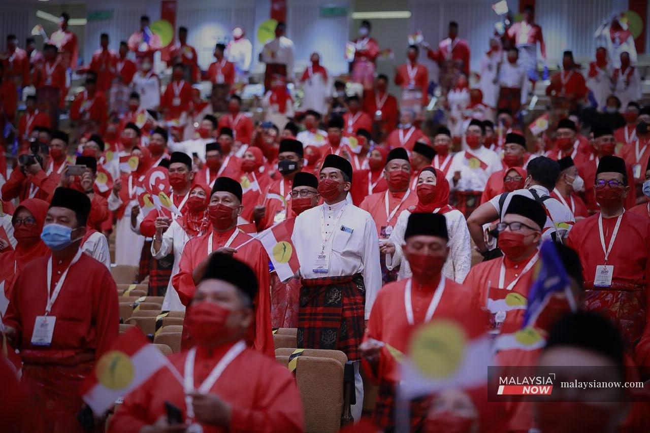 Perwakilan-perwakilan berdiri menyanyikan lagu patriotik pada Persidangan Umno 2020 di Pusat Dagangan Dunia Putra.