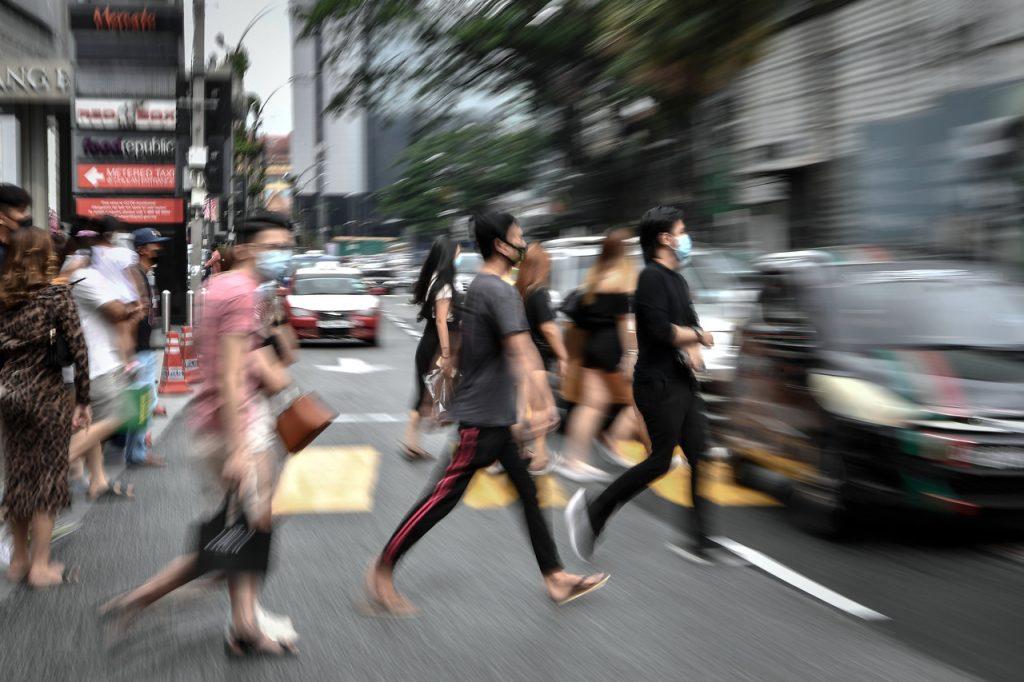 Pedestrians cross a road in Kuala Lumpur, one of six states to remain under conditional movement control order. Photo: Bernama