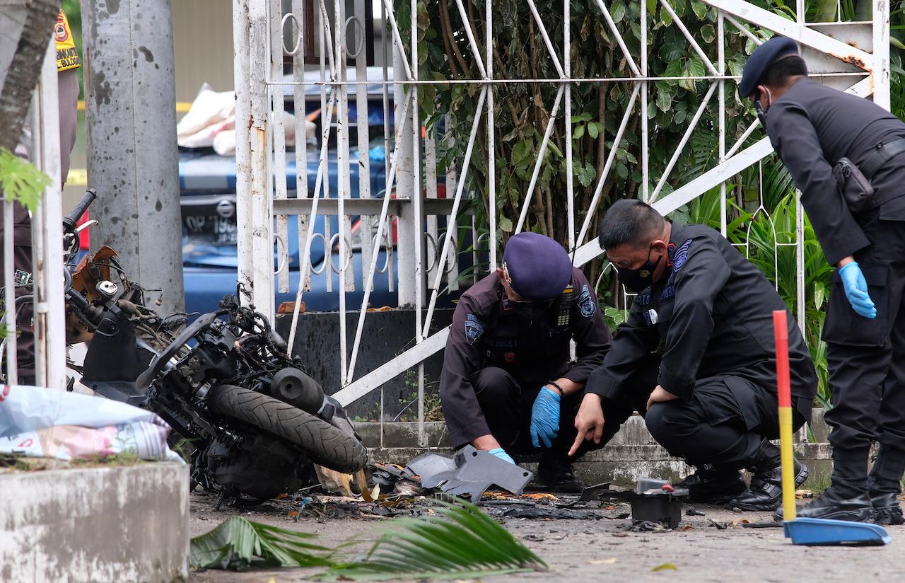 Members of a police bomb squad inspect the wreckage of a motorbike used to carry out Sunday's suicide bomb attack at the Sacred Heart of Jesus Cathedral in Makassar, South Sulawesi, Indonesia, March 29. Photo: AP