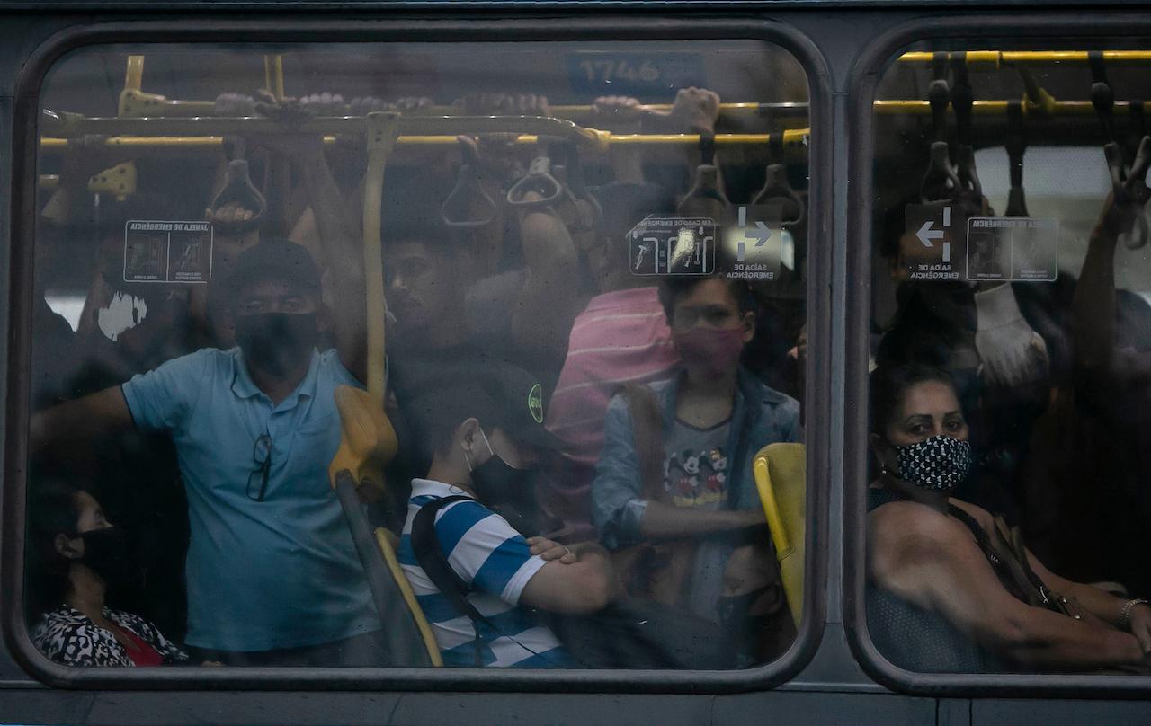 Commuters wearing masks due to the Covid-19 pandemic crowd a public Rapid Transit Bus in Rio de Janeiro, Brazil, March 30. Nearly 314,000 people have died of Covid-19 in Brazil, second only to the US. Photo: AP