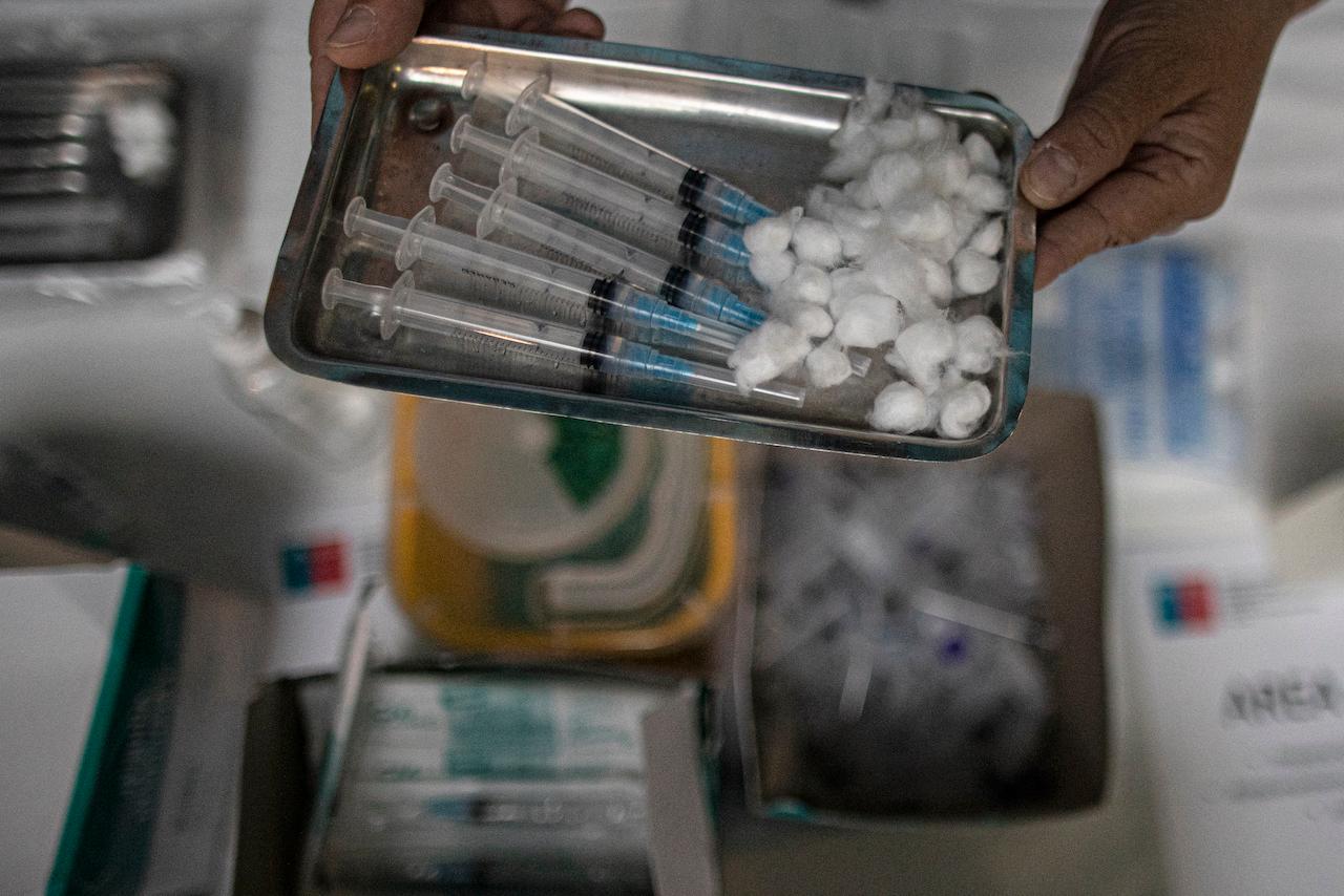 A health worker holds a tray of syringes filled with the Pfizer-BioNTech Covid-19 vaccine, which has been used in millions of adults in more than 65 countries. Photo: AP