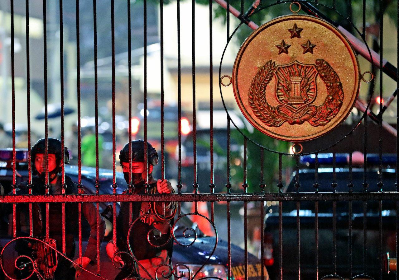 Police officers stand guard at the main gate of the national police headquarters following a suspected militant attack in Jakarta, Indonesia, March 31. Photo: AP
