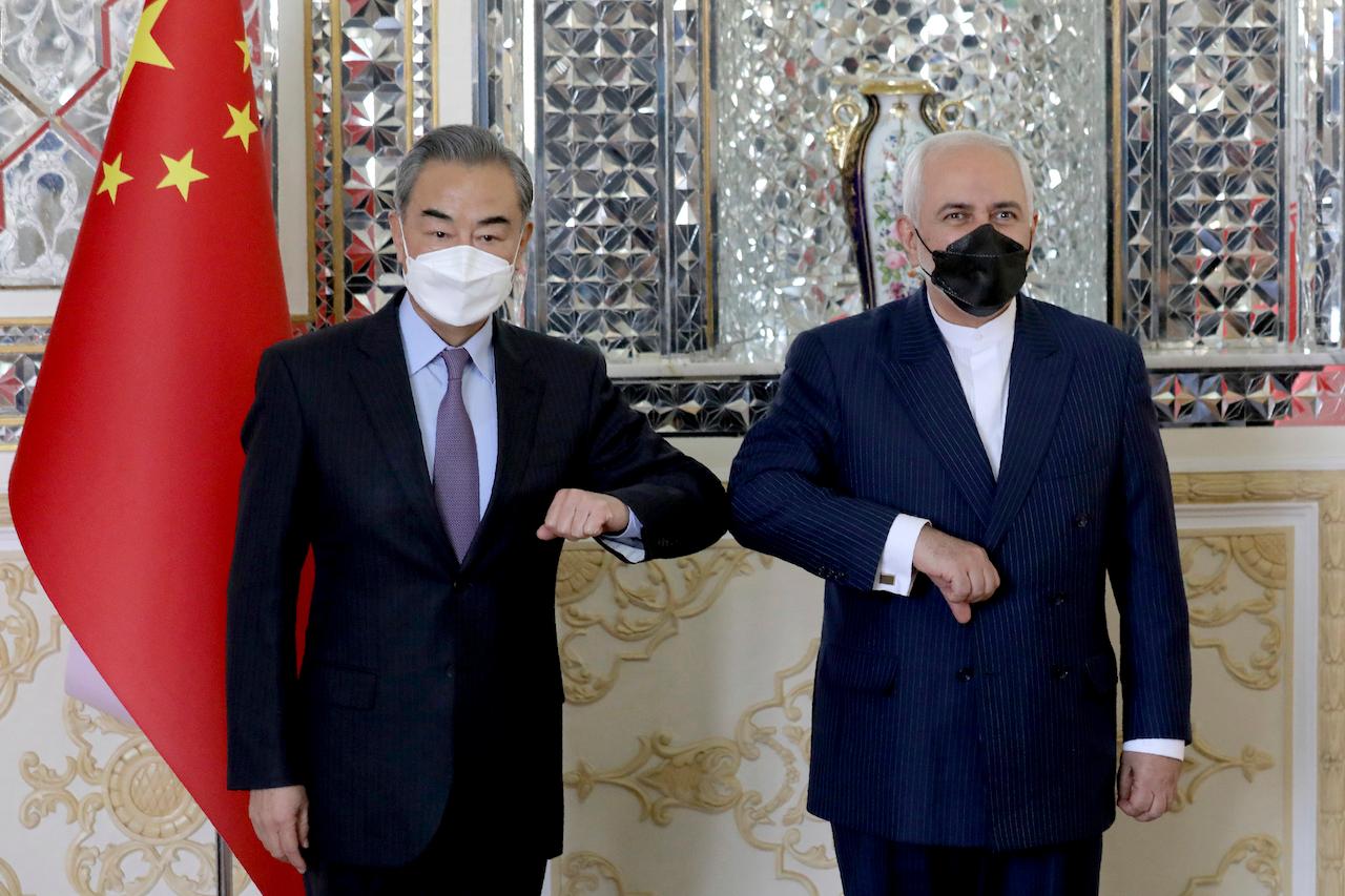Iranian Foreign Minister Mohammad Javad Zarif (right) and his Chinese counterpart Wang Yi pose for photos at the start of their meeting in Tehran, Iran, March 27. Iran and China on Saturday signed a 25-year strategic cooperation agreement addressing economic issues amid crippling US sanctions on Iran. Photo: AP