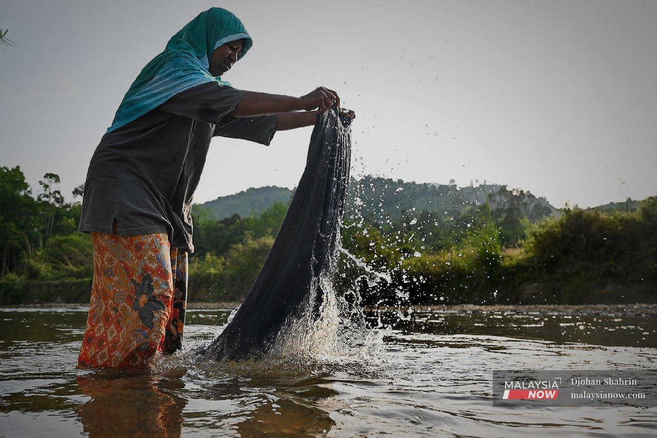 Seorang penduduk di Kampung Bukit Sebelah terpaksa cuci baju di sungai. Rata-rata penduduk di daerah Baling kecewa dengan pengurusan air di negeri tersebut.
