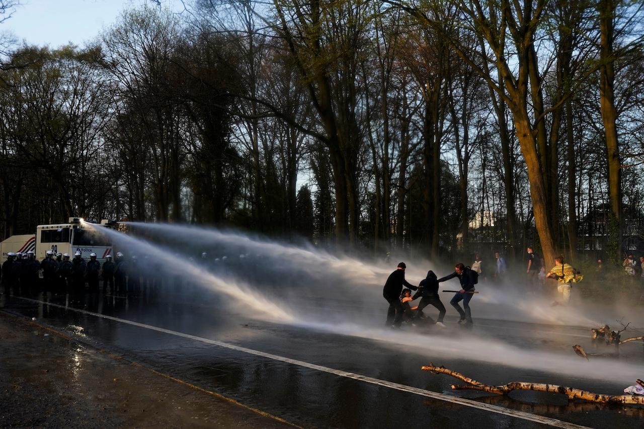 People are sprayed by a police water cannon during a protest at Bois de la Cambre park in Brussels, April 1. Belgian police clashed with a crowd in one of Brussels' largest parks, as thousands of revellers gathered for an unauthorised event despite coronavirus restrictions. Photo: AP
