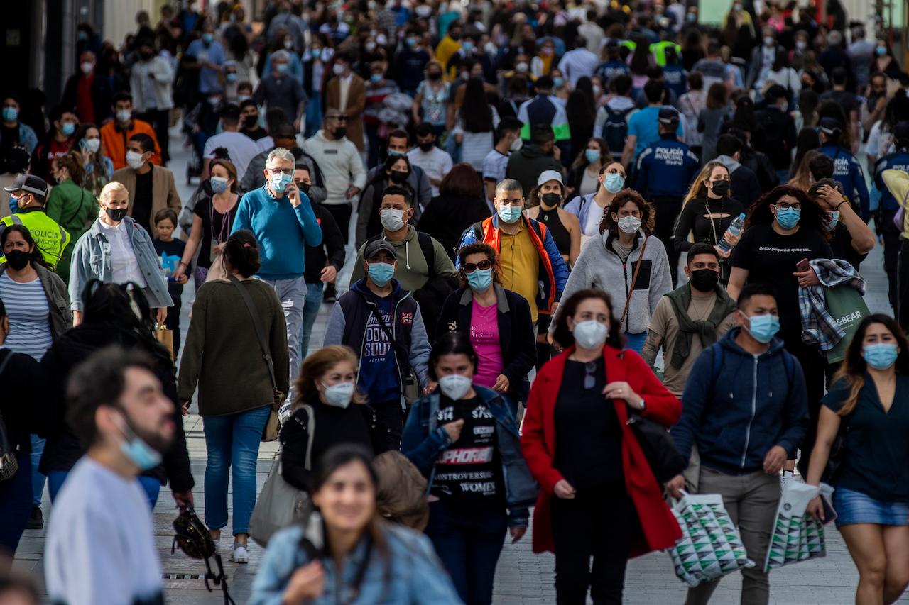 People wearing face masks to protect against the spread of coronavirus walk in downtown Madrid, Spain, March 31. Spain is bracing for another potential sharp increase in coronavirus cases. Photo: AP