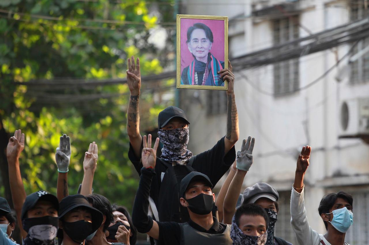 Anti-coup demonstrators raise the three-finger salute of resistance and a portrait of deposed leader Aung San Suu Kyi as they prepare to confront the police during a protest in Tarmwe township, Yangon, Myanmar, April 1. Photo: AP