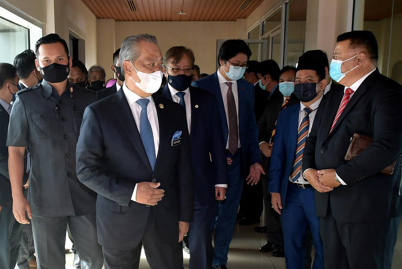 Prime Minister Muhyiddin Yassin (second left) upon his arrival at the Kuching International Airport for his two-day visit on April 1. Also present was Sarawak Chief Minister Abang Johari Openg (third left). Photo: Bernama