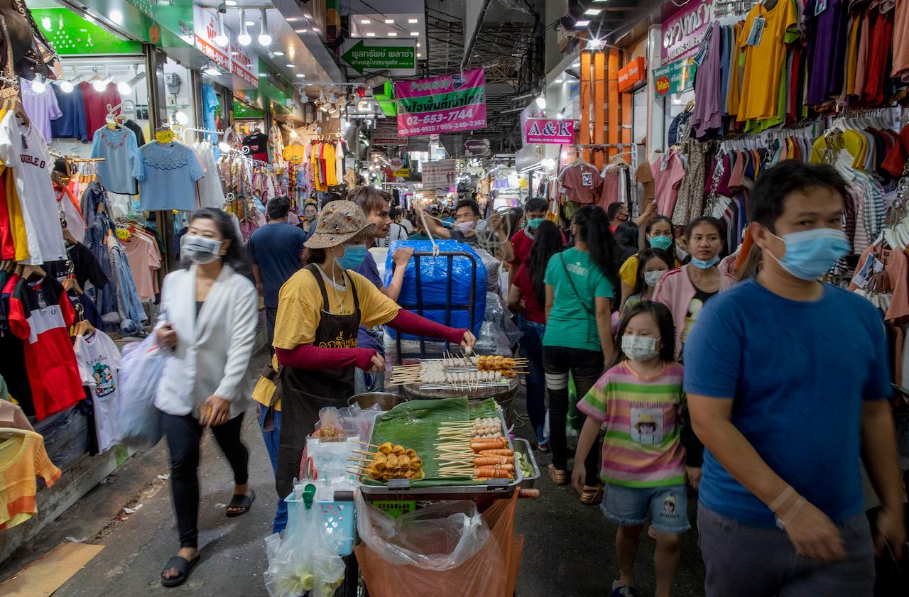 In this Aug. 6, 2020, file photo, shoppers walk though a clothing market in Bangkok, Thailand. The government has promised one trillion baht in relief to ease the impact of the Covid-19 outbreak, but some say relief is not being rolled out fast enough for many Thais. Photo: AP