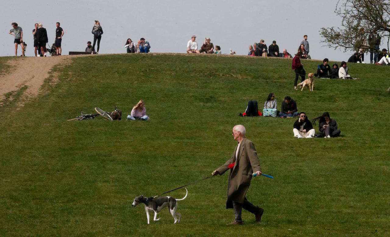 People enjoy the view during sunny weather at Primrose Hill in London, April 1. Britain plans to issue identification showing whether people are vaccinated, have antibodies or have tested negative, despite opposition from lawmakers in Prime Minister Boris Johnson's own party. Photo: AP