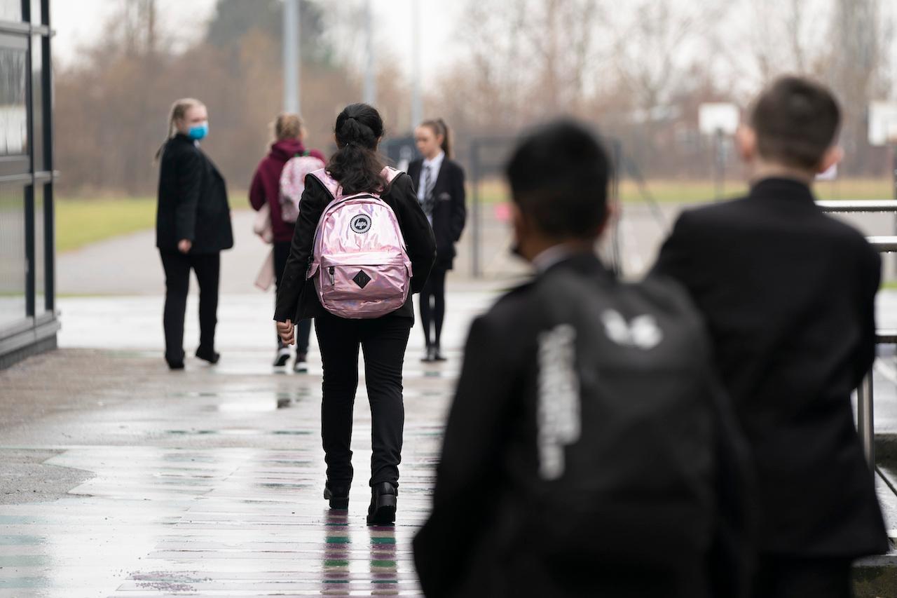 Pupils wearing face masks to curb the spread of Covid-19 arrive at a school in Manchester, England, March 8. Photo: AP