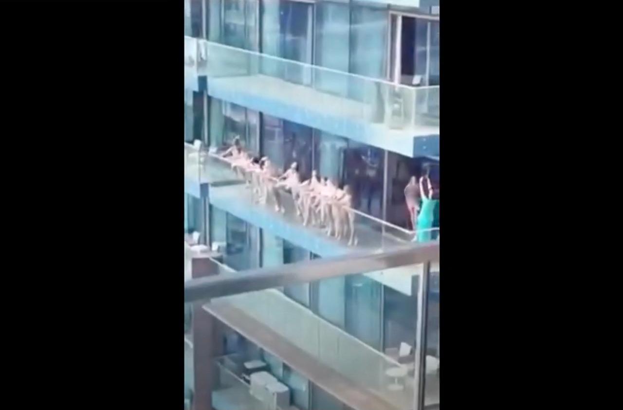 A screenshot of a widely shared video showing naked women posing on a balcony in the Marina Lake Towers districts of Dubai, UAE.