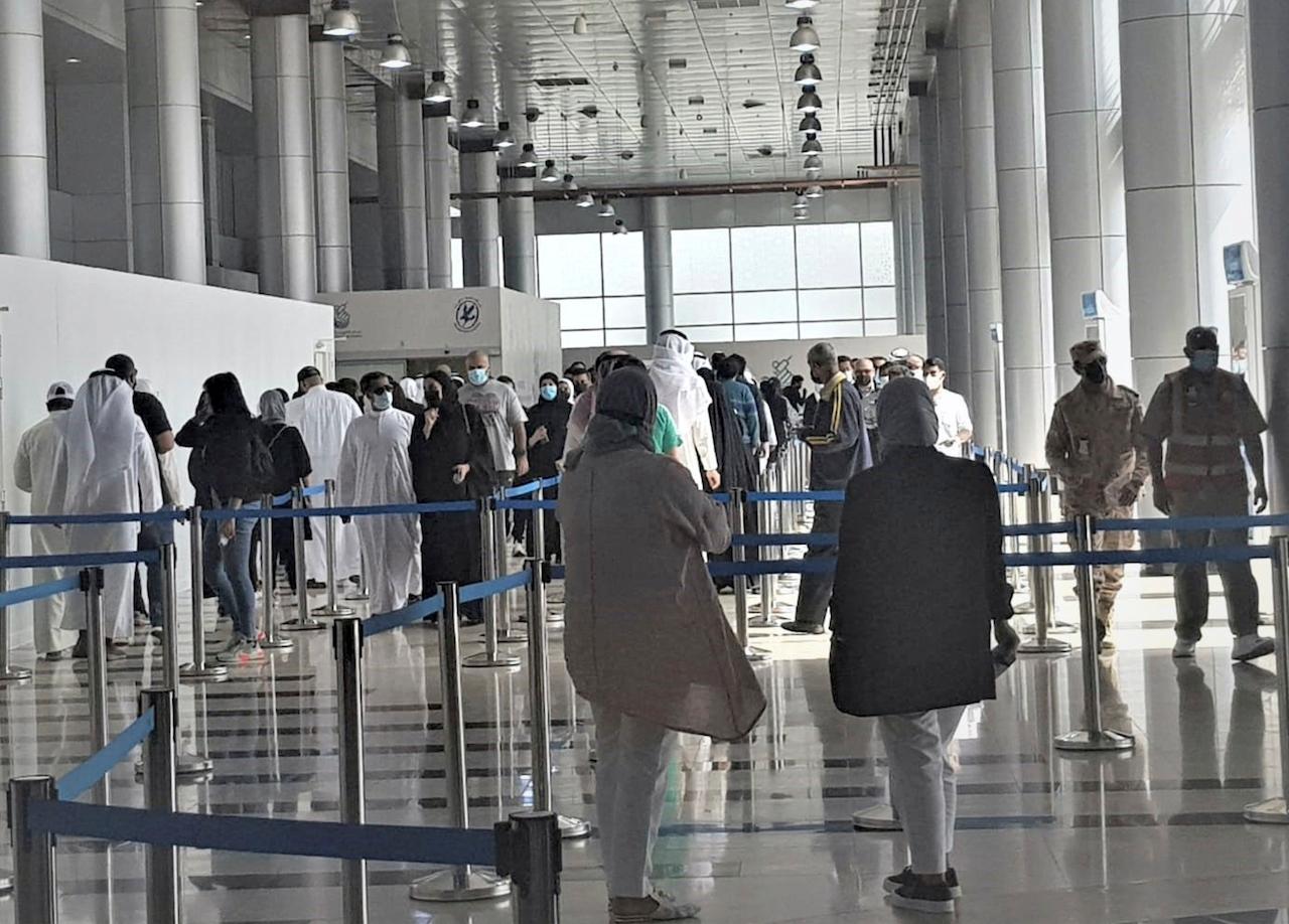 People stand in line at the Kuwait Vaccination Centre to receive their jabs in Kuwait, March 12. In the tiny, oil-rich sheikhdom, the foreigners who power the country's economy, serve its society and make up 70% of its population are struggling to get Covid-19 vaccines. Photo: AP