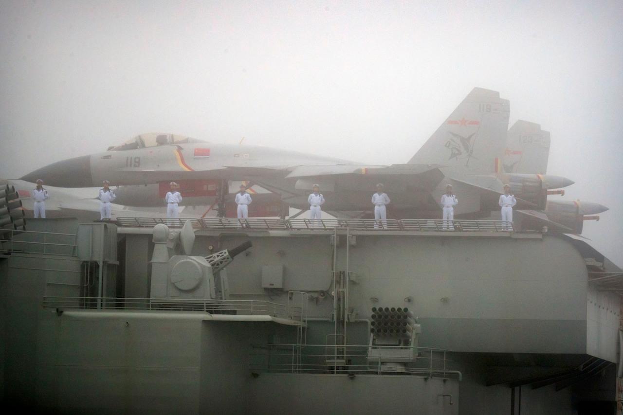 Sailors stand near fighter jets on the deck of the Chinese People's Liberation Army Navy aircraft carrier Liaoning as it participates in a naval parade in the sea near Qingdao in eastern China's Shandong province, April 23, 2019. The Liaoning was one of several ships in a Chinese carrier strike group heading towards the Pacific last weekend. Photo: AP