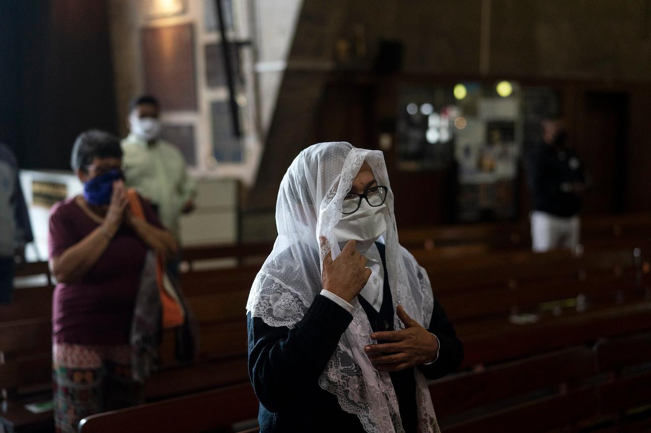 A woman wearing a face mask and traditional veil attends a Mass at the Metropolitan Cathedral, in Rio de Janeiro, Brazil, July 4, 2020. Photo: AP