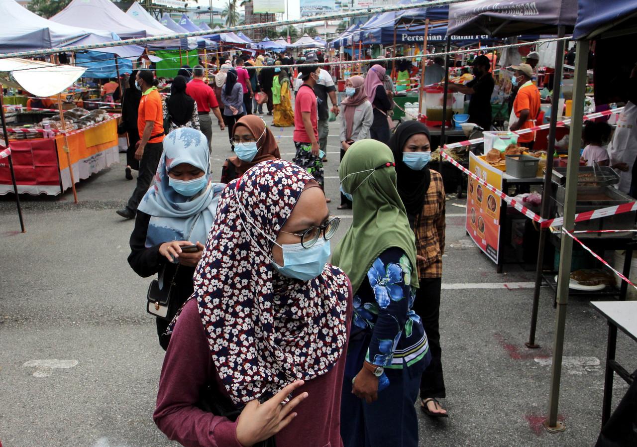 Customers line up according to health SOPs before entering a market in Kuantan, Pahang. Photo: Bernama