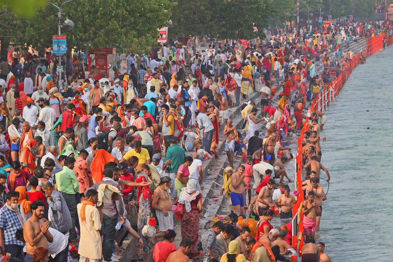 Devotees take a dip in the river Ganges in Haridwar in the Indian state of Uttarakhand, April 12. Experts have warned that huge, mostly maskless and tightly packed crowds at political rallies, mass religious festivals and other public places are fuelling the new wave of infections. Photo: AP