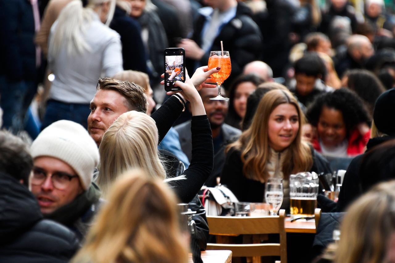 A woman takes a picture of her drink in Soho, London, on the day some of England's coronavirus lockdown restrictions were eased by the government, April 12. Photo: AP