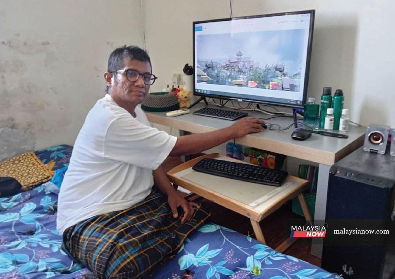 Mohd Faizal Rahmat at his work station at his house in Kuala Lumpur. He has carried his computer with him throughout his many moves.