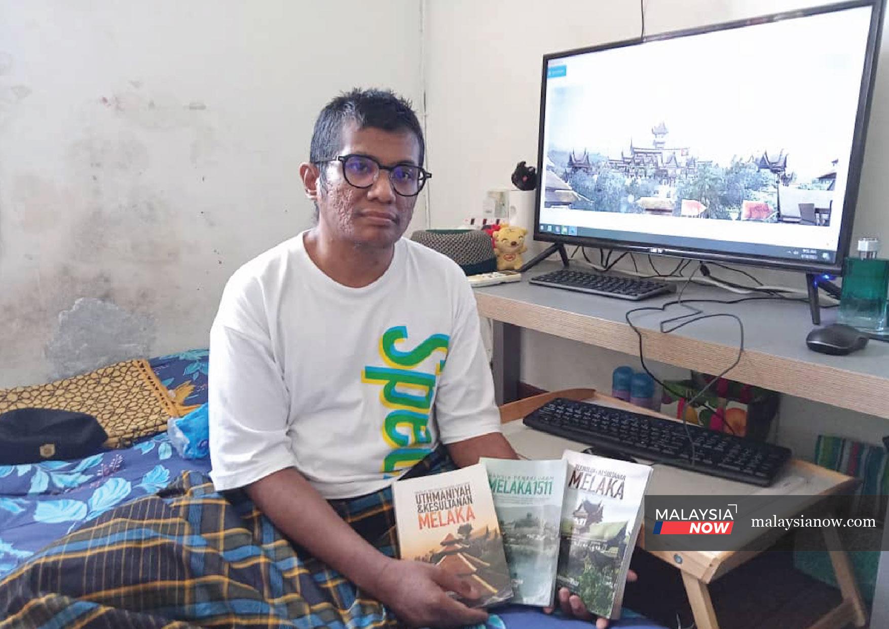 Mohd Faizal Rahmat menunjukkan beberapa buku yang memuatkan lukisan 3D yang dihasilkannya.