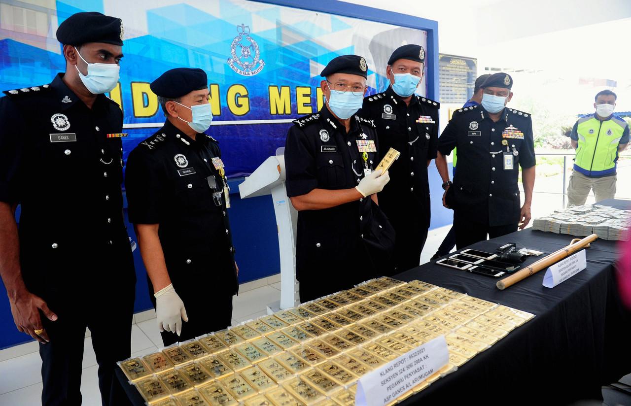 Selangor police chief Arjunaidi Mohamed (third left) shows the gold bars seized after the arrest of four men for allegedly assaulting two others for fasting. Photo: Bernama