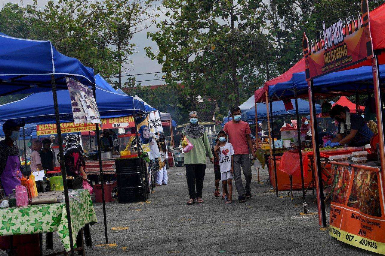 A family strolls through a Ramadan bazaar in Alor Setar, Kedah, April 13. Kedah Menteri Besar Muhammad Sanusi Md Nor says levels of compliance with SOPs at the bazaars have been low. Photo: Bernama