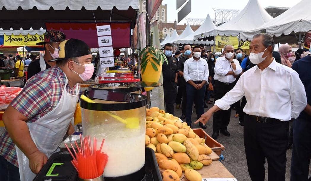 Prime Minister Muhyiddin Yassin pauses by a stall during his visit to a Ramadan bazaar in Precint 3, Putrajaya, yesterday.