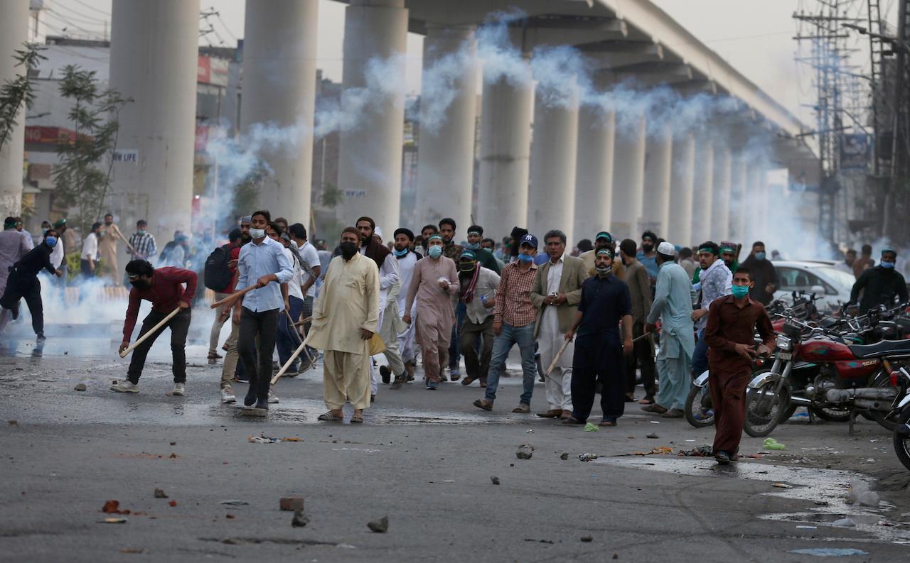 Angry supporters of Tehreek-e-Labiak Pakistan, a radical Islamist political party, throw stones towards police firing tear gas to disperse them, at a protest against the arrest of their leader Saad Rizvi, in Lahore, Pakistan, April 12. Pakistan police arrested Rizvi a day after he threatened the government with protests if it did not expel France's ambassador over depictions of Islam's Prophet Muhammad. Photo: AP