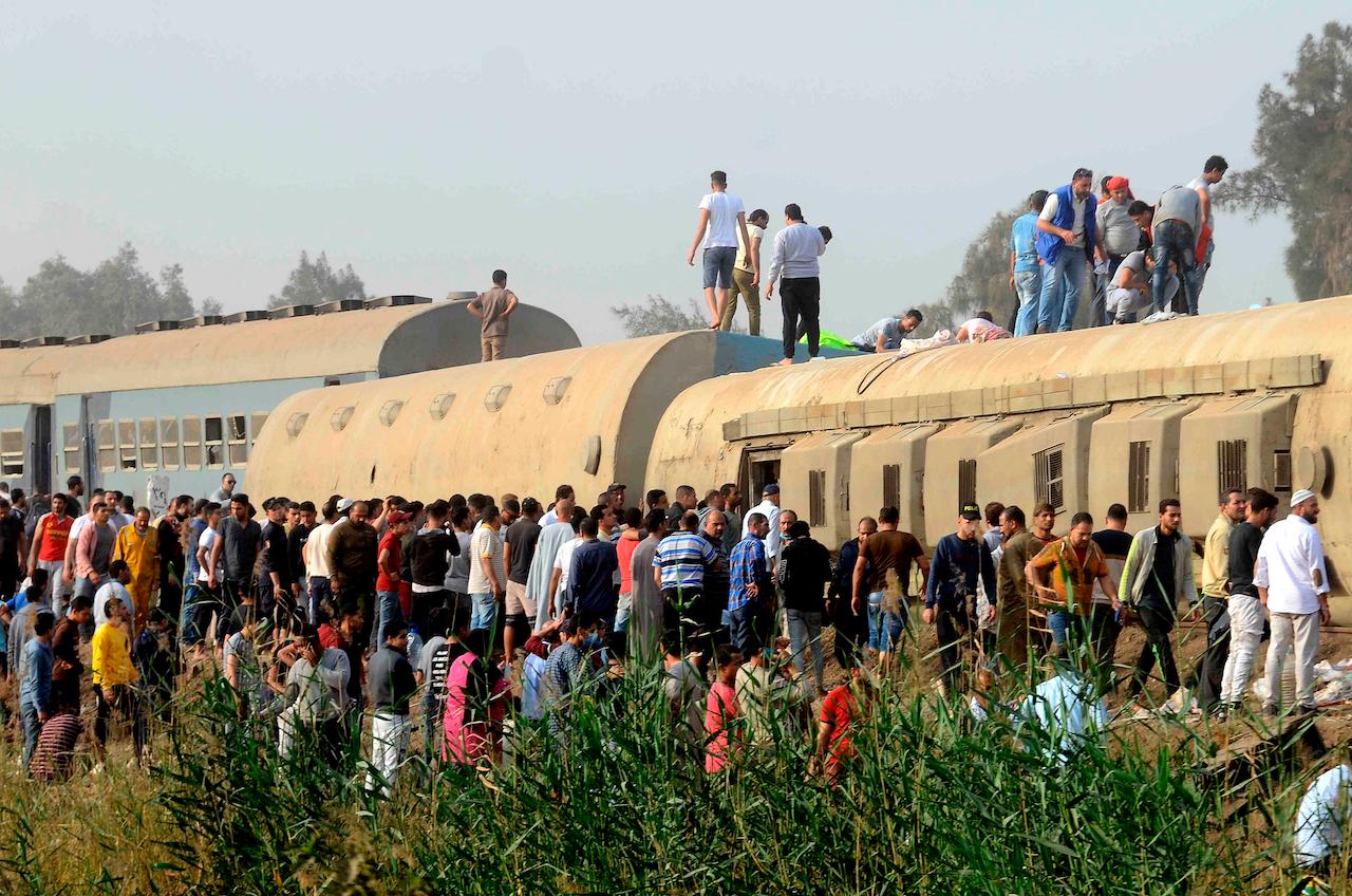 People gather at the site where a passenger train derailed injuring at least 100 people, near Banha, Qalyubia province, Egypt, April 18. At least four train wagons were said to have run off the railway. Photo: AP