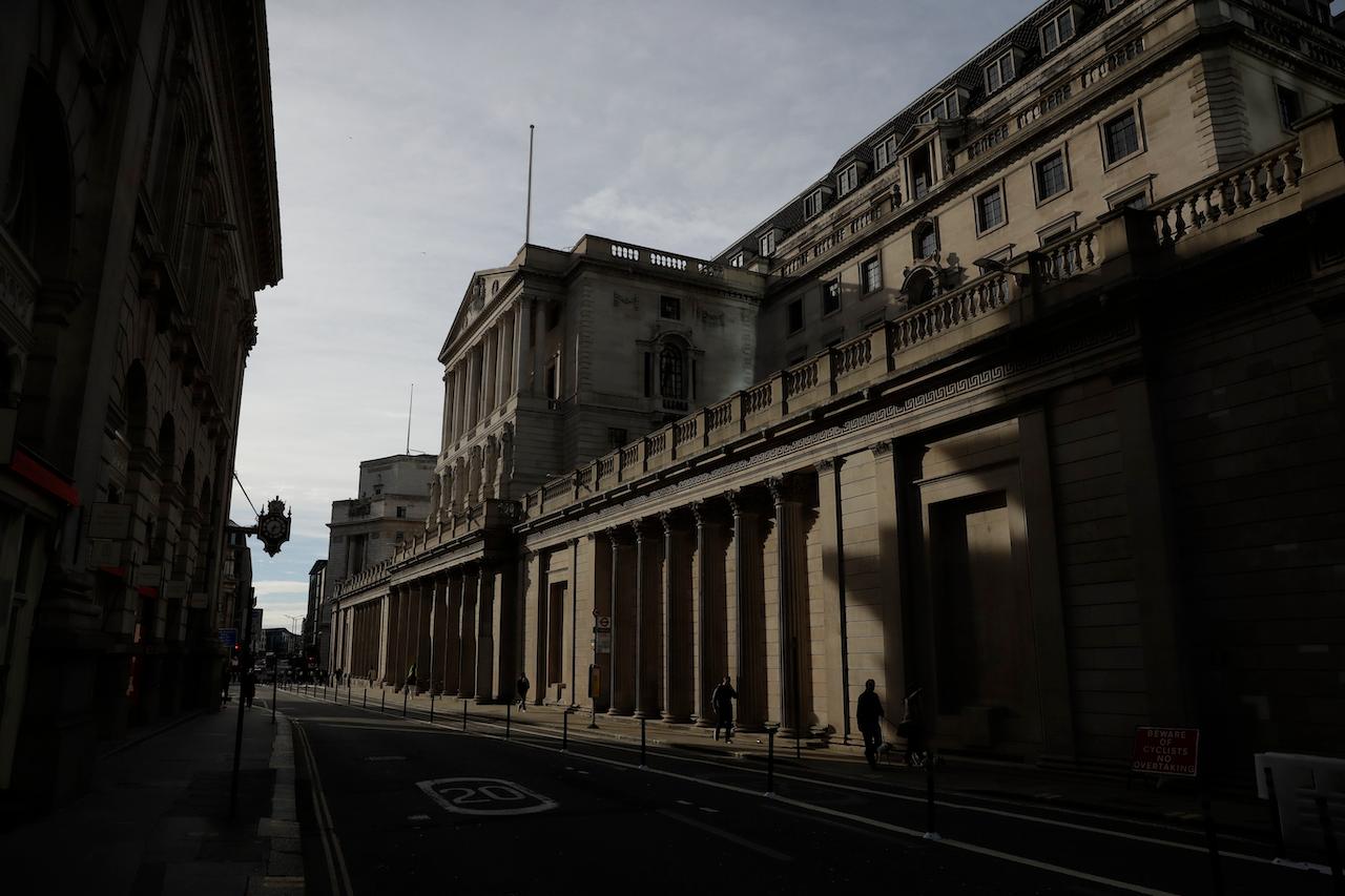 People walk past the Bank of England in the financial district of London, during England's third coronavirus lockdown, Feb 23. The use of cash has fallen during the coronavirus pandemic as people try to avoid contact. Photo: AP