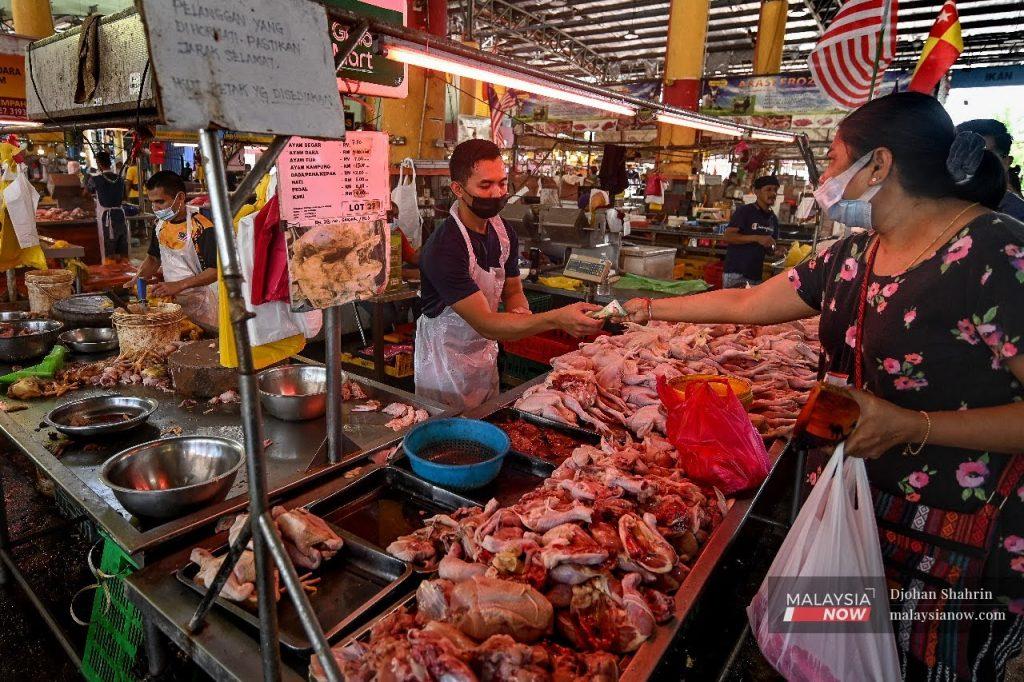 Seorang pelanggan membeli ayam segar di Pasar Borong Selangor, Seri Kembangan.