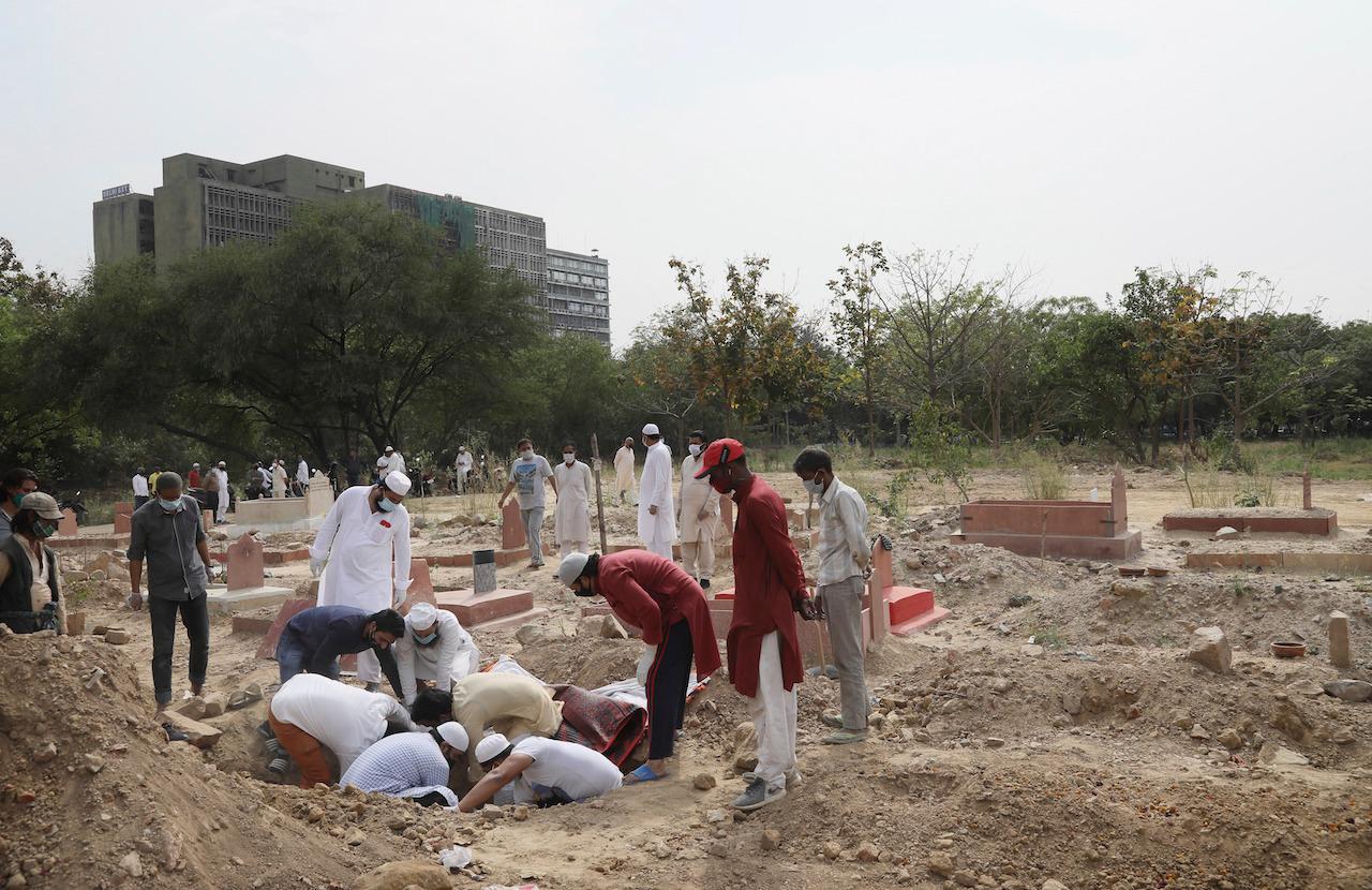 Relatives bury the body of a Covid-19 victim for at graveyard in New Delhi, India, April 5. Officially, almost 180,000 Indians have died from coronavirus, 15,000 of them this month. Photo: AP