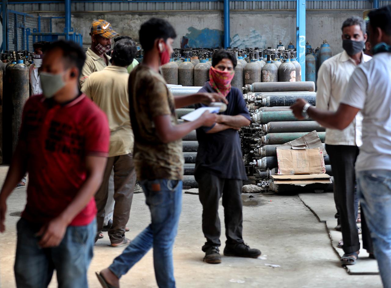Ambulance drivers and others wait to receive oxygen cylinders at a gas supplier facility in Bengaluru, India, April 21. India has been overwhelmed by hundreds of thousands of new coronavirus cases daily, with lockdowns in place in Delhi and other cities. Photo: AP