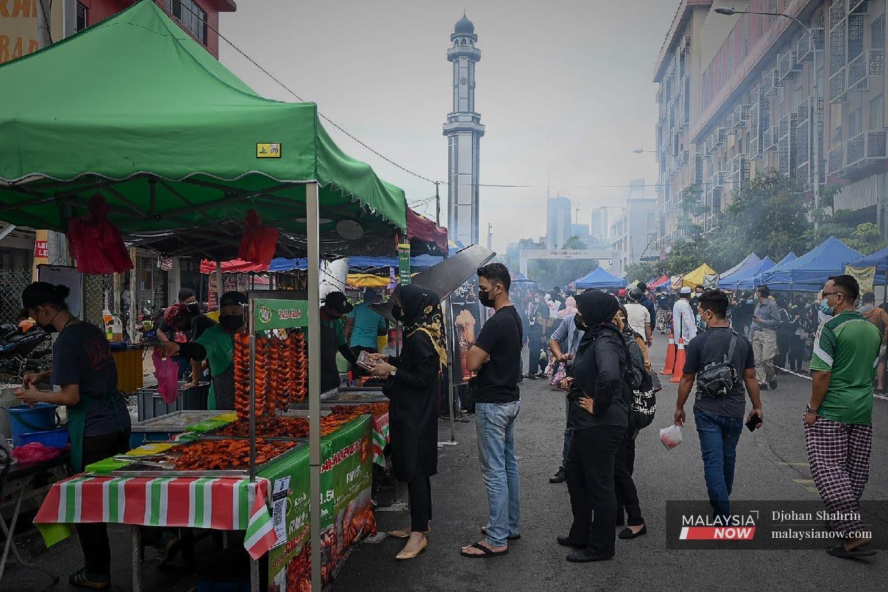 Customers queue at a stall at a Ramadan bazaar in Kampung Baru, Kuala Lumpur.