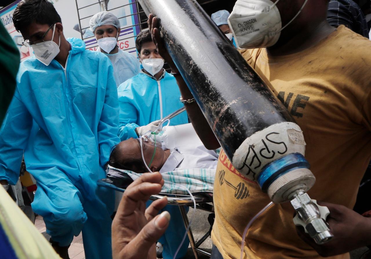 Health workers carry a patient after a fire at the Vijay Vallabh Covid-19 hospital in Virar, near Mumbai, India, April 23. The fire killed 13 Covid-19 patients as an extreme surge in coronavirus infections leaves the nation short of medical care and oxygen. Photo: AP