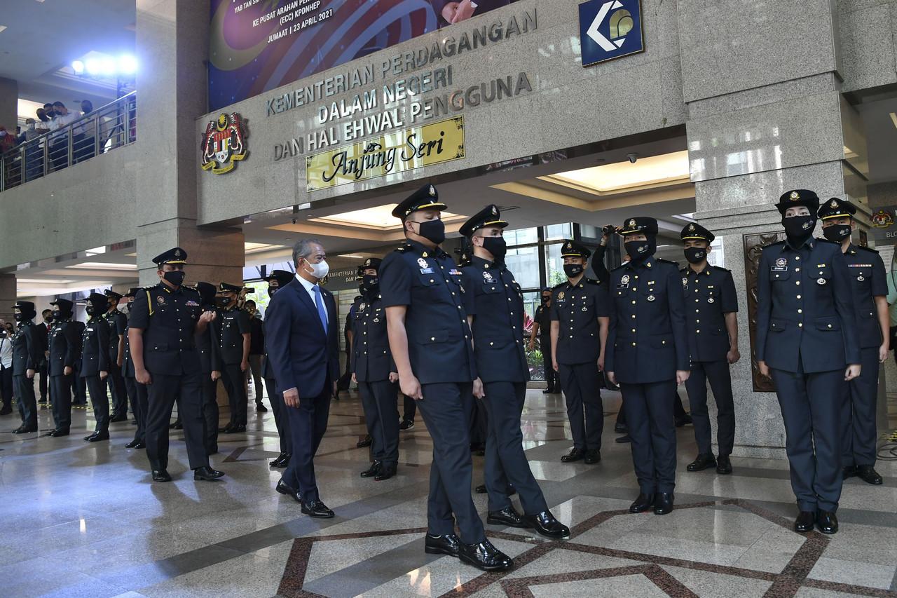 Perdana Menteri Muhyiddin Yassin melakukan pemeriksaan barisan pegawai penguatkuasa semasa mengadakan lawatan kerjanya ke pusat arahan penguatkuasaan (EEC) kementerian perdagangan dalam negeri dan hal ehwal pengguna (KPDNHEP) hari ini. Gambar: Bernama