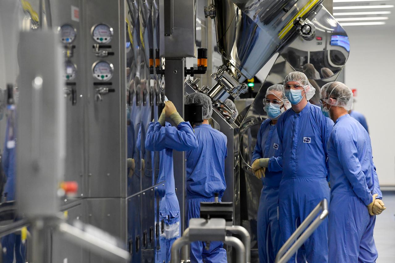 Employees work at the Pfizer pharmaceutical company in Puurs, Belgium, April 23. The European Union is betting big on Pfizer's relatively expensive vaccine, but there are concerns that the difficulty of keeping it at very cold temperatures will make it hard to distribute in poorer countries. Photo: AP