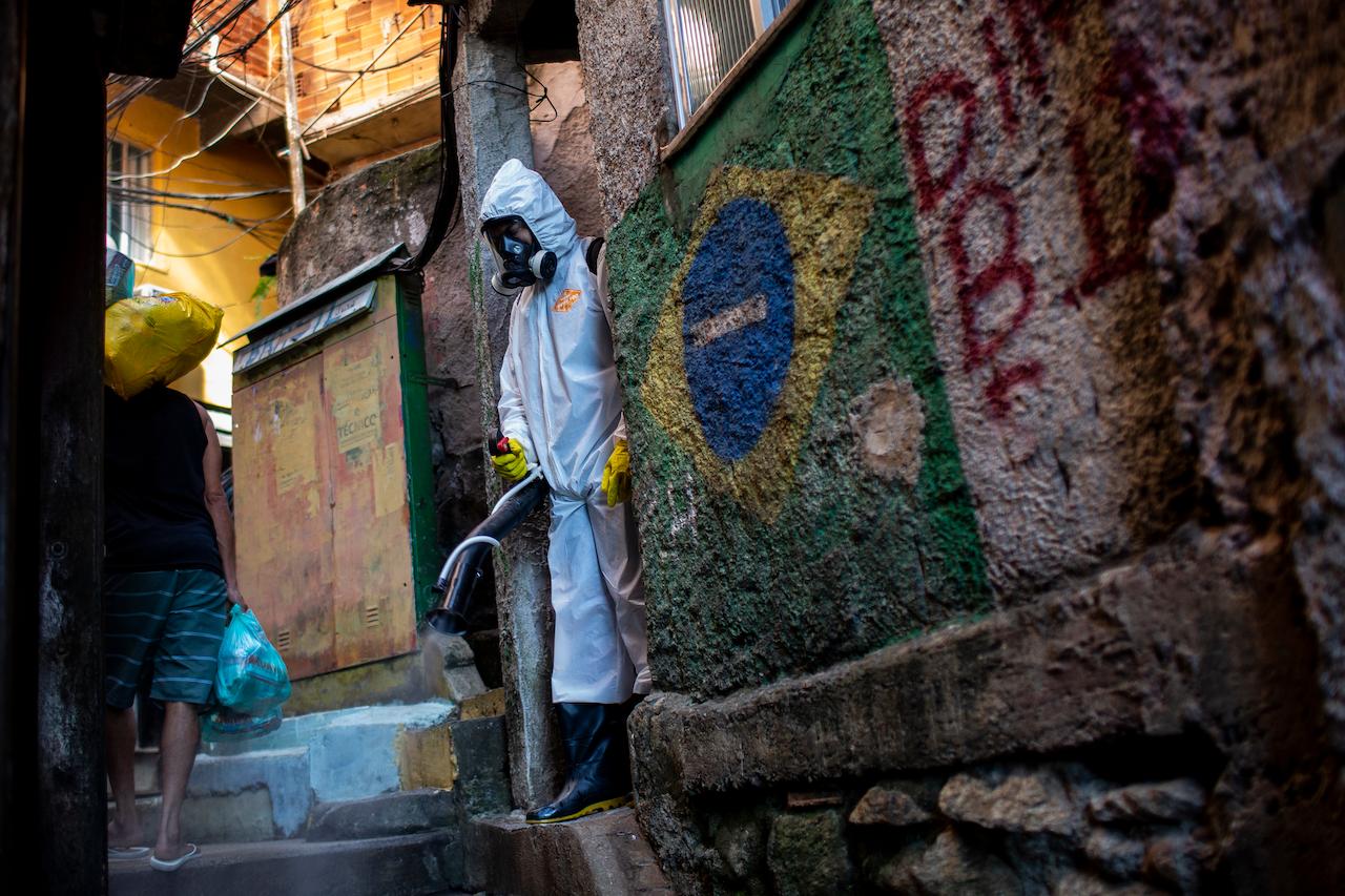 A health worker sprays disinfectant in an alley to help contain the spread of Covid-19, in the Santa Marta slum of Rio de Janeiro, Brazil, April 24. In the past 24 hours, Brazil recorded 3,076 deaths, with a seven-day average of 2,545 deaths per day. Photo: AP