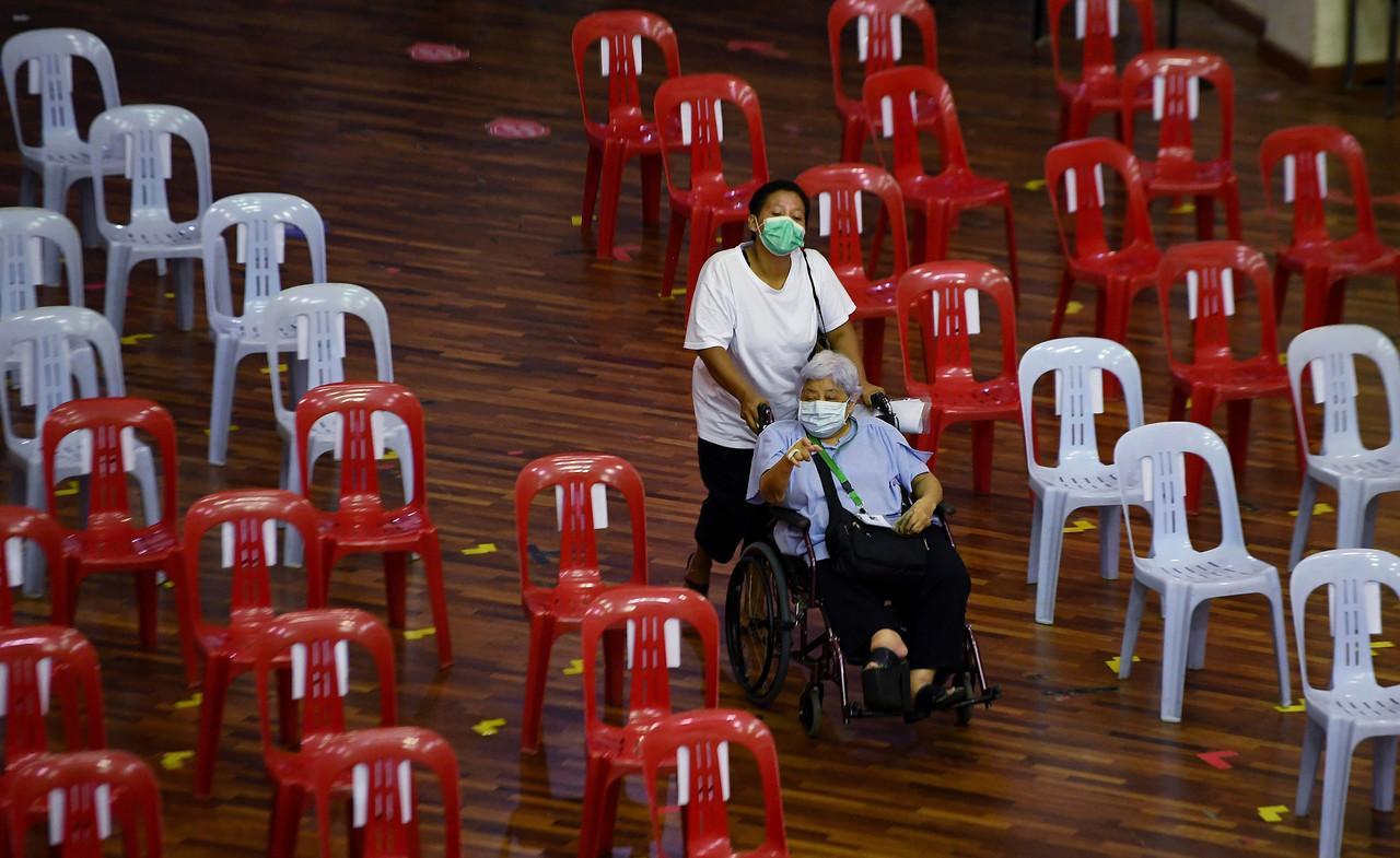 A senior citizen accompanied by her helper arrive at Wisma Belia for her fist dose of Covid-19 vaccine in Kuantan, Pahang. Photo: Bernama
