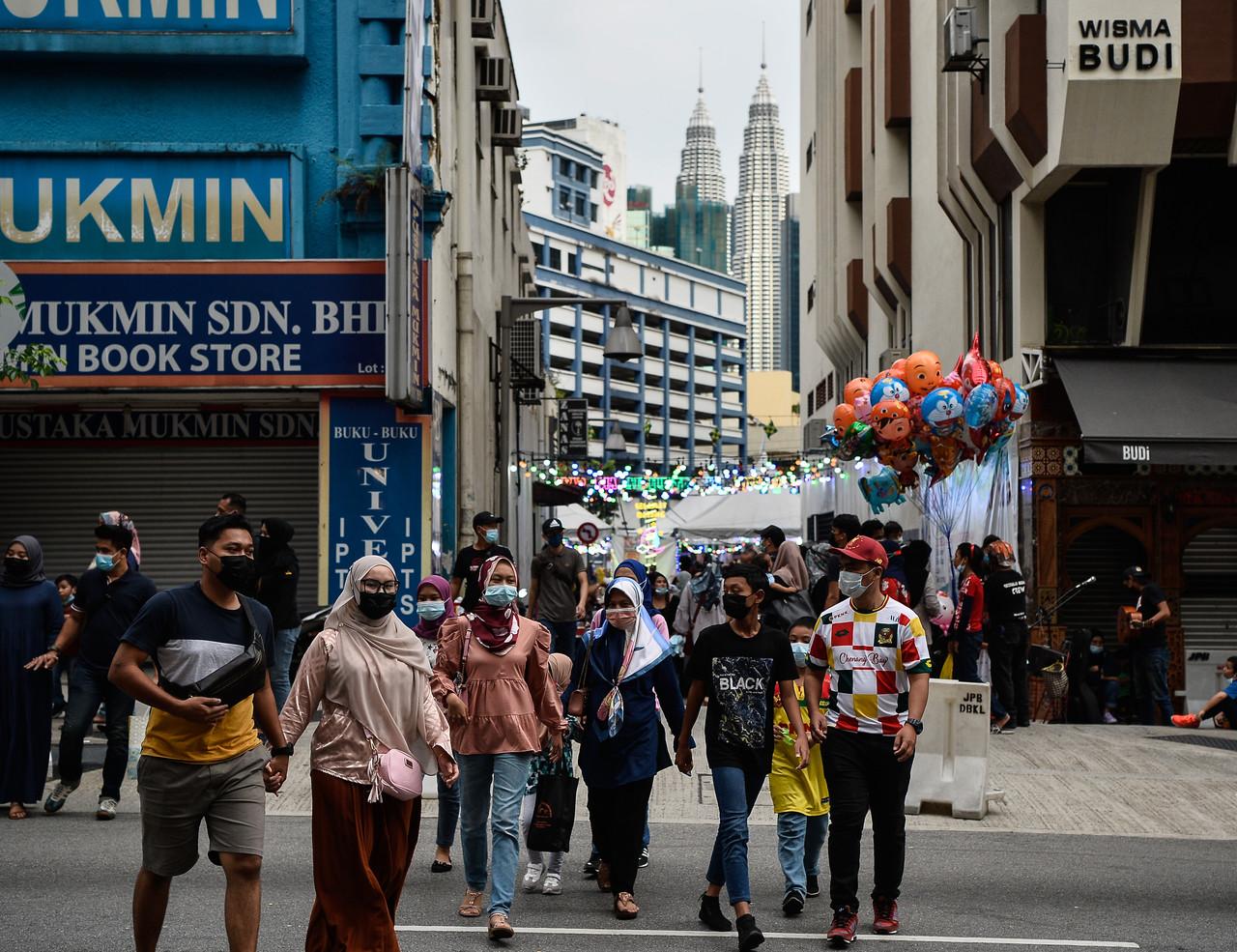 Pedestrians wearing face masks leave an Aidilfitri bazaar in the Lorong Tuanku Abdul Rahman area in Kuala Lumpur. Photo: Bernama