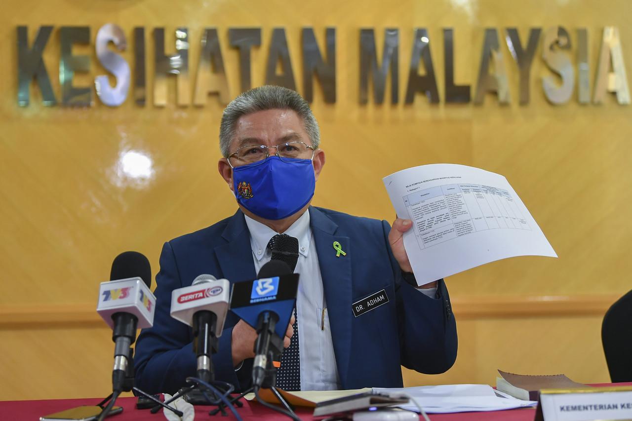 Health Minister Dr Adham Baba shows a breakdown of compound amounts based on the magnitude of offence for breaching Covid-19 SOPs at a press conference on March 31. Photo: Bernama