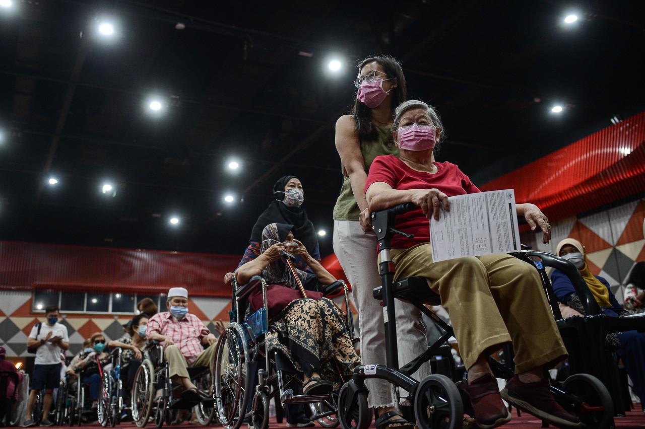 Senior citizens and those from the high-risk group queue to receive their first dose of Covid-19 vaccine under the second phase of the national immunisation programme at the Sunway Convention Centre in Petaling Jaya. Photo: Bernama