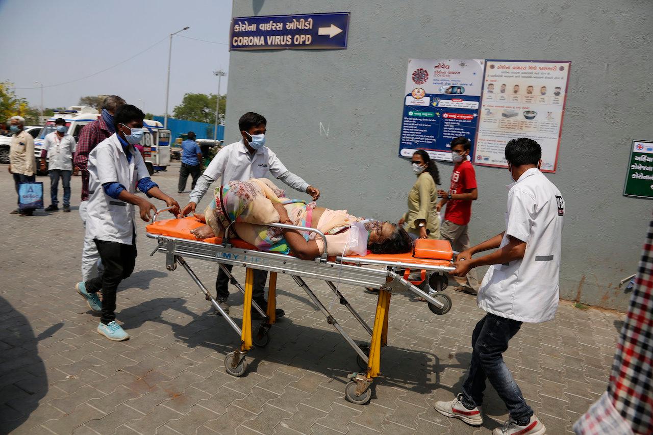 Health workers bring a patient to be admitted at a government Covid-19 hospital in Ahmedabad, India, April 27. Coronavirus cases in India are surging faster than anywhere else in the world. Photo: AP