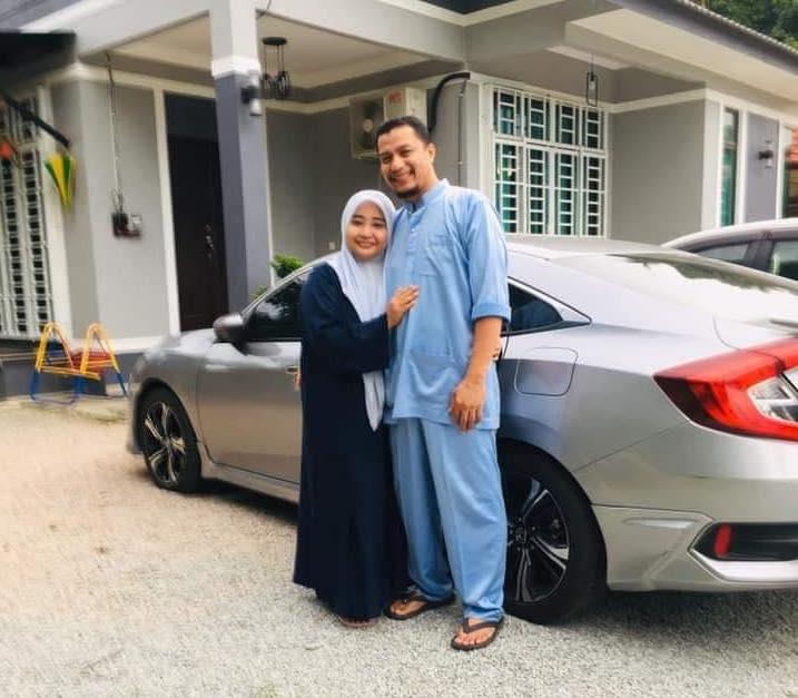 A picture of burger seller Wan Mohd Faisal Wan Kadir and his wife Norlaili Shafii with their car outside their house, which has been making the rounds on social media.