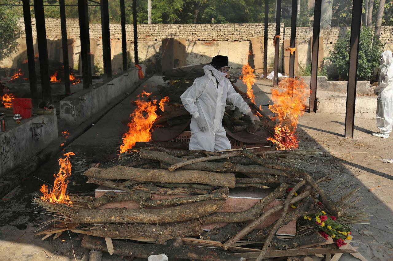 A family member performs the last rites of a Covid-19 victim at a crematorium in Jammu, in Jammu, India, April 30. Photo: AP