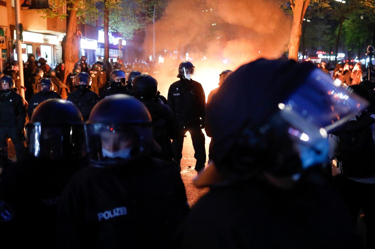 Police officers stand in front of a fire set up by demonstrators during a May Day rally in Berlin, Germany, May 1. Photo: AP