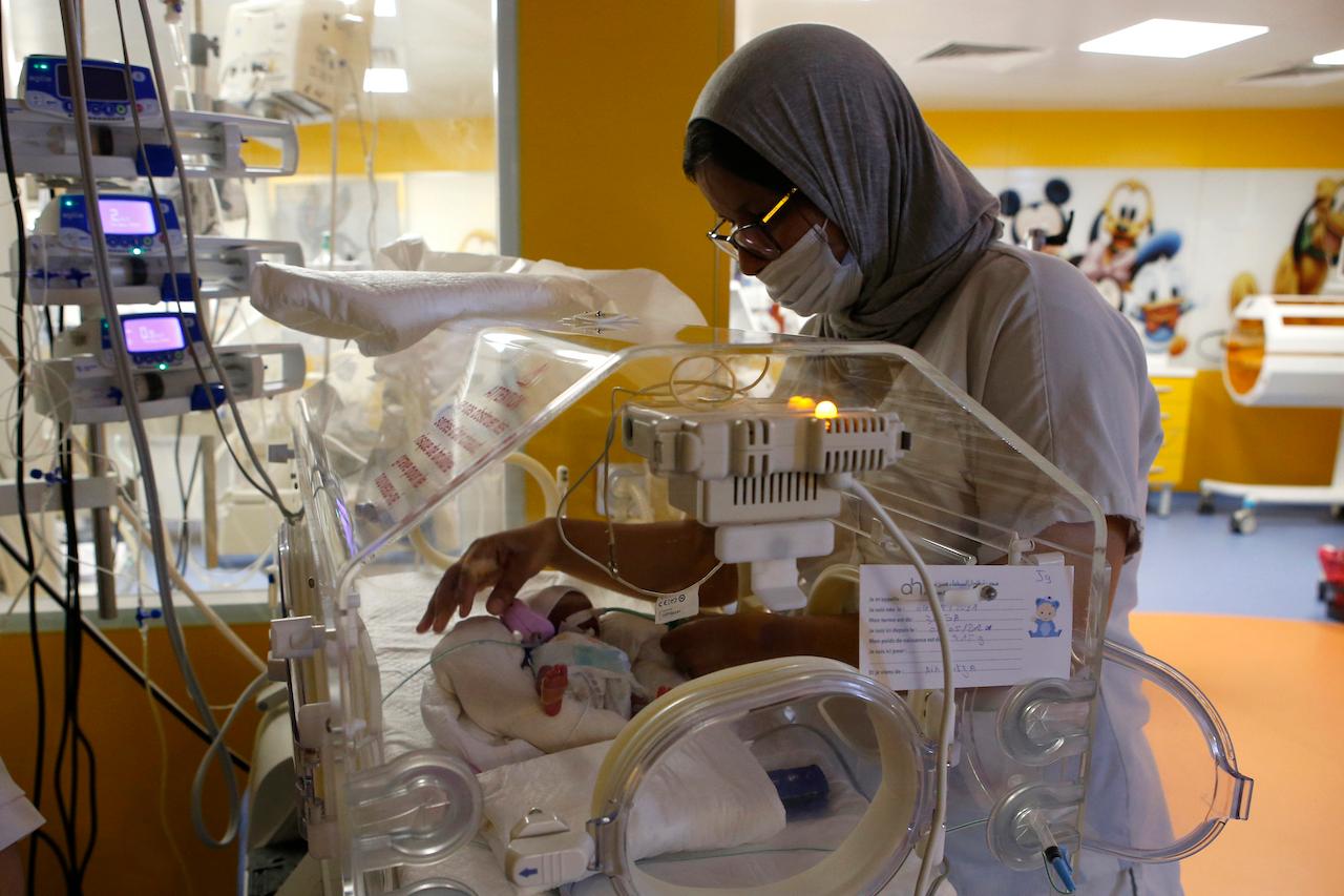 A Moroccan nurse takes care of one of the nine babies protected in an incubator at the maternity ward of the private clinic of Ain Borja in Casablanca, Morocco, May 5. Photo: AP