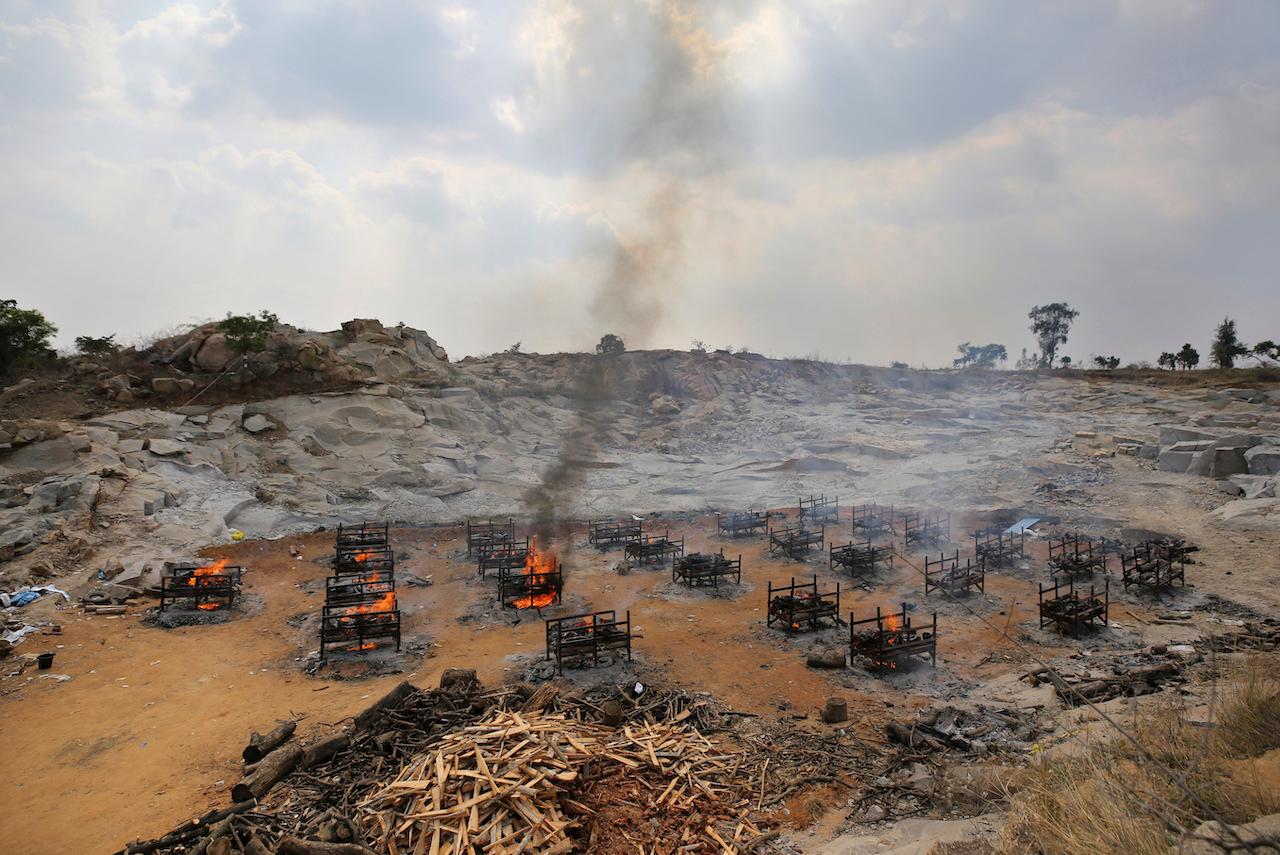 Funeral pyres of 25 Covid-19 victims burn at an open crematorium set up at a granite quarry on the outskirts of Bengaluru, India, May 5. Photo: AP
