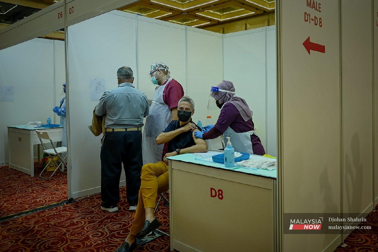 A health worker administers a shot of the AstraZeneca vaccine for Covid-19 at the World Trade Centre in Kuala Lumpur.