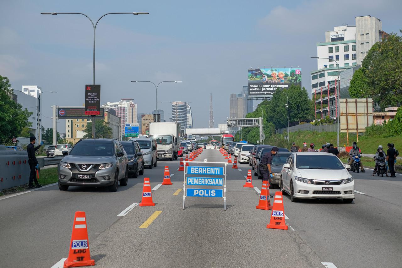 Police man a roadblock along the Federal Highway heading towards Kuala Lumpur, which is under movement control order along with most districts in Selangor. Photo: Bernama